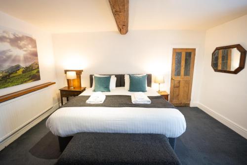 a bedroom with a large bed with blue pillows at Without A Paddle Hotel in Llangollen