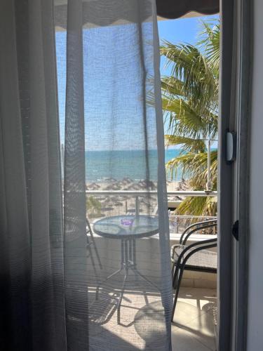 Un balcón con mesa y vista a la playa. en Super Seaview Apartment, en Durrës