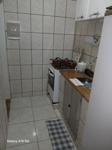 a small kitchen with a stove and a sink at Condominium House in Iguaba in Iguaba Grande