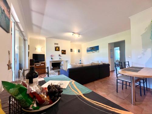 a living room with a couch and a table at Golf and Beach Serenity in Aroeira