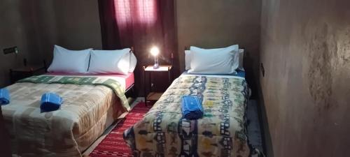 two beds sitting next to each other in a room at PALM'SKOURA in Skoura