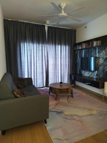 a living room with a couch and a flat screen tv at Sweet Escape at Splashmania in Banting