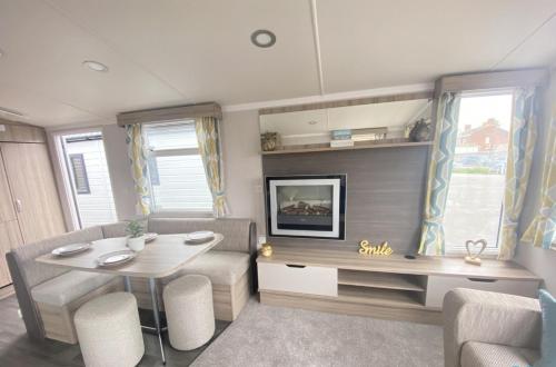 a living room with a table and a tv at 15 Willow Wynd Thurston Manor in Dunbar