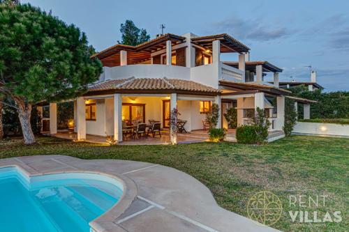 a villa with a swimming pool and a house at Beachfront Villa Armonia in Porto Hydra by goutos properties in Ermioni