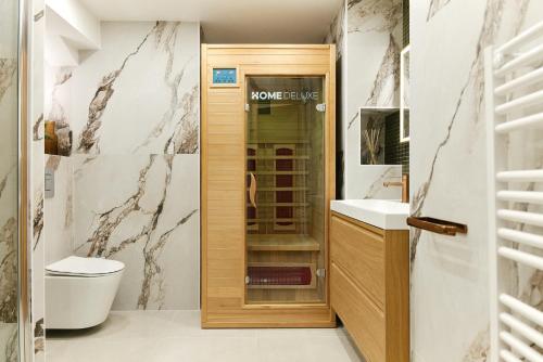 Un baño con inodoro y puerta de madera. en Lavie Maison Marais Sauna Hot Tub, en París