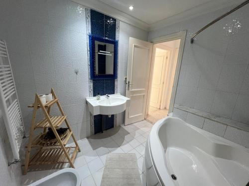 a bathroom with a bath tub and a sink at Cozy apartment Chatt Meriem in Hammam Sousse