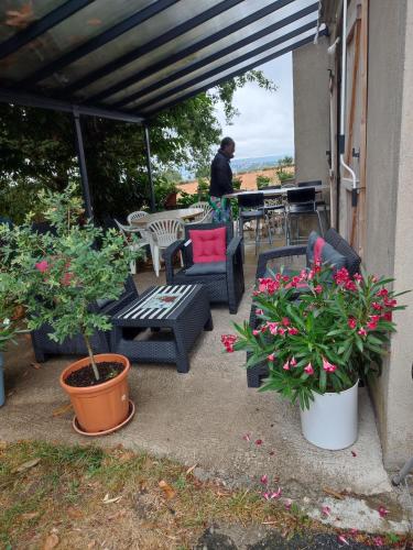 un patio avec des chaises, des tables et des plantes en pot dans l'établissement Maison d ôte, à La Celle-sous-Gouzon