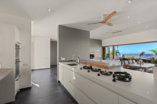 a large white kitchen with a view of the ocean at Villa Lahara with spectacular views in Dorp Soto