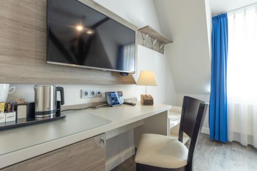 a office with a desk with a coffee maker on it at Best Western Plus Theodor Storm Hotel in Husum