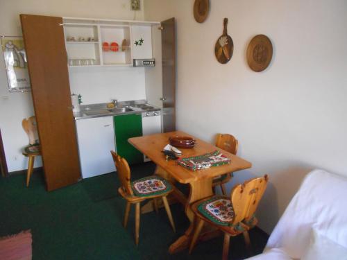 セストリエーレにあるMonolocale Milky Way - Sestriereのテーブルと椅子、キッチンが備わる客室です。
