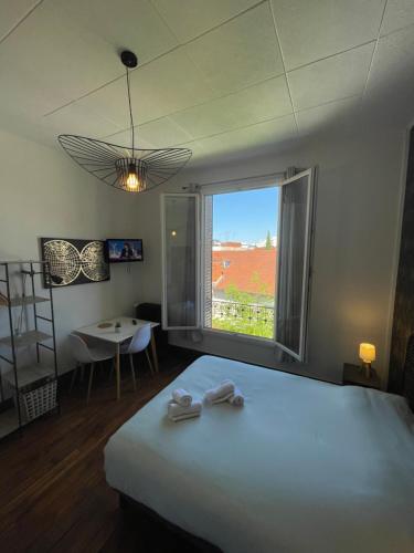 une chambre avec un lit et une grande fenêtre dans l'établissement Opale 3, à Vichy