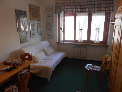 salon z kanapą, stołem i oknem w obiekcie Monolocale Milky Way - Sestriere w mieście Sestriere