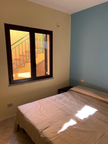 a bedroom with a bed and a window at Casa Arborea in Agrustos