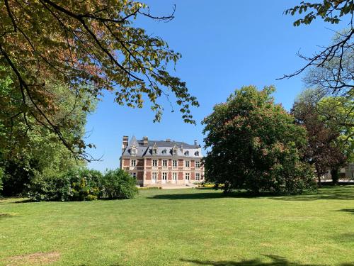 a large house in the middle of a field with trees at Château du Mont de Guny in Guny