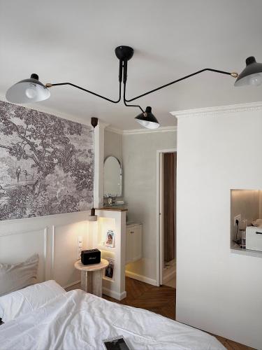 une chambre avec un lit et un tableau au mur dans l'établissement Appartement Opéra centre Paris, à Paris