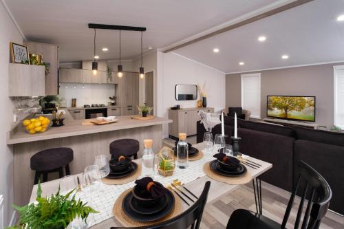 a dining room and kitchen with a table and chairs at Crofthead Holiday Park in Ayr