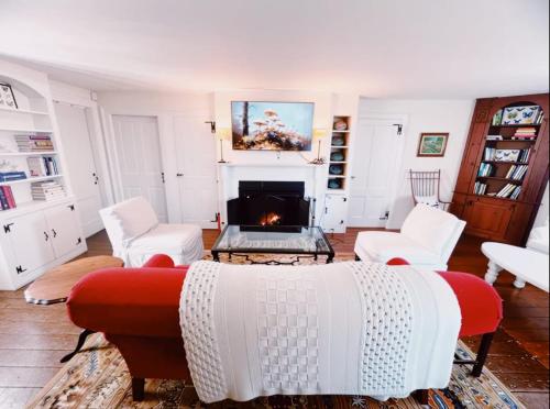 a living room with a couch and a fireplace at Capt Clarke Historic Homestead Venue in Old Saybrook
