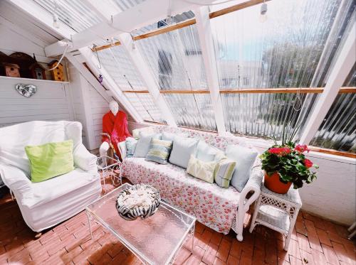 a screened in porch with a couch and a table at Capt Clarke Historic Homestead Venue in Old Saybrook