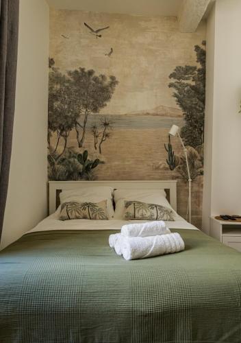 une chambre avec un lit avec un tableau sur le mur dans l'établissement Le Nid de l'Ecusson, à Montpellier