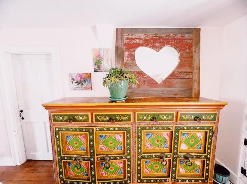 a wooden dresser with a heart on the wall at Capt Clarke Historic Homestead Venue in Old Saybrook