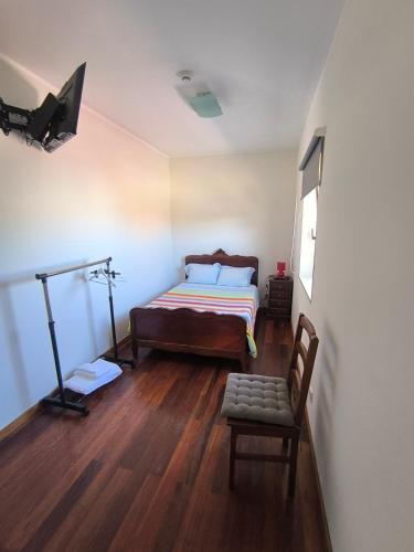 a bedroom with a bed and a tv and a chair at Casa Velha in Matosinhos