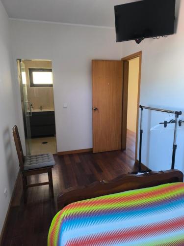 a bedroom with a bed and a chair and a television at Casa Velha in Matosinhos