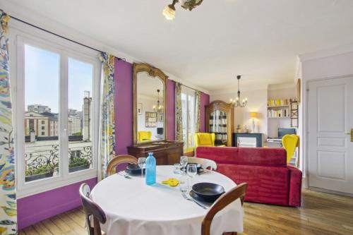 un salon avec une table et un canapé rouge dans l'établissement Authentic Parisian apartment, à Paris