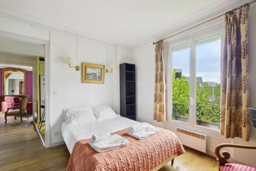 une chambre avec un lit et une grande fenêtre dans l'établissement Authentic Parisian apartment, à Paris