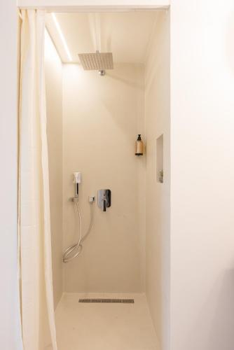 a bathroom with a shower with a phone on the wall at Chariclea Villas Retreat in Samos
