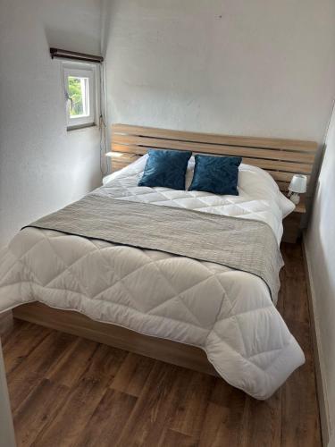 a bedroom with a large bed with blue pillows at Casa bela paisagem in Castro Daire