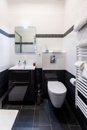 - une salle de bains en noir et blanc pourvue de toilettes et d'un lavabo dans l'établissement Paris Square, à Paris