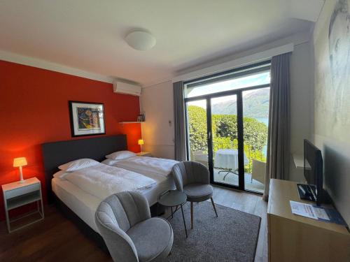 a hotel room with a bed and a large window at Art Hotel Ristorante Posta Al Lago in Ronco s/Ascona - Porto Ronco