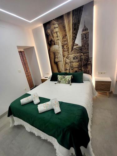 a bedroom with a large bed with two pillows on it at El Capricho de Vandelvira in Úbeda