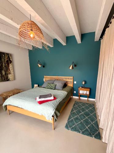 une chambre avec un lit et un mur bleu dans l'établissement Nid douillet sur roof top, à Perpignan