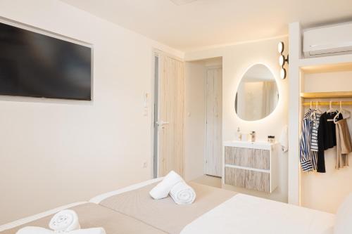 a white bedroom with a bed and a mirror at Chariclea Villas Retreat in Samos