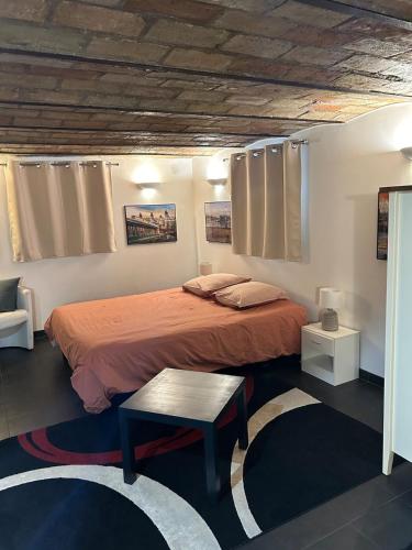 a bedroom with a bed and a table in it at Studio 29 m2 proche La Défense et Arena in Nanterre