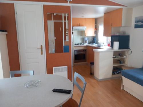 une petite cuisine avec une table et une salle à manger dans l'établissement L'évasion, à La Bernerie-en-Retz