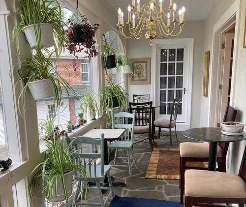 a dining room with tables and chairs and potted plants at Sleepy Hollow Manor in Gettysburg
