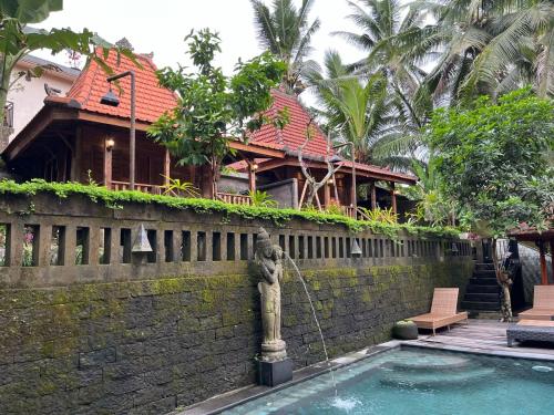 a house with a water fountain in front of a building at Sweet Orange Pondok in Ubud