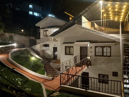 uma casa com piscina à noite em The Vintage Haven Munnar em Devikolam