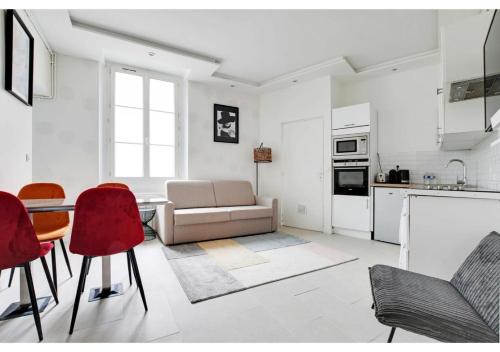 un salon avec un canapé, une table et des chaises dans l'établissement Beautiful Apartment Marais Bastille, à Paris