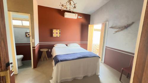 a bedroom with a bed in a room with a window at Casa Cacto Pousada in Pão de Açúcar