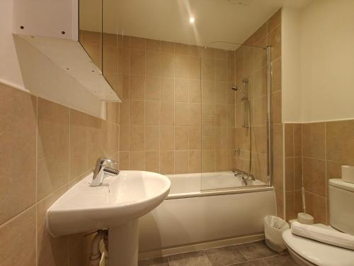 een badkamer met een wastafel, een bad en een toilet bij Park Central 4 Double Bedroom House in Birmingham City Center in Birmingham