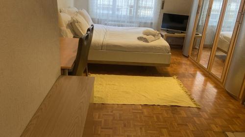 a bedroom with a bed and a yellow rug at Swiss Flats in Lausanne