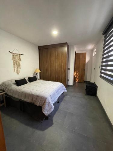 a bedroom with a large bed in a room at Departamento en Chapala in Ixtlahuacán de los Membrillos