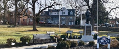 a park with benches and a statue in front of a building at Sleepy Hollow Manor in Gettysburg