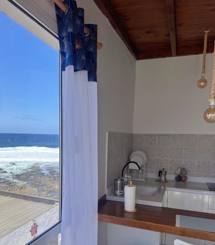 a kitchen with a view of the ocean from a window at Marina in La Santa