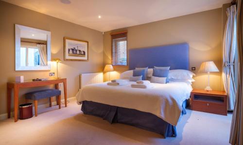 Un dormitorio con una cama grande con cabecero azul. en Robinson, en Keswick