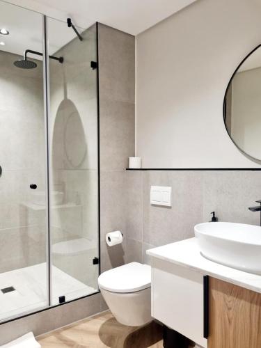 a bathroom with a toilet and a sink and a shower at On Park by Smart City Stays in Cape Town