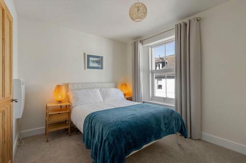 een slaapkamer met een bed en een raam bij Picnic Cottage - Family Retreat near Dartmouth in Kingswear